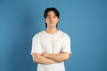 Portrait of asian man posing on blue background