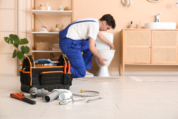 Tool bag with pipes and plumber tools in bathroom, closeup