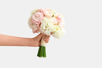 Hand with beautiful wedding bouquet on white background