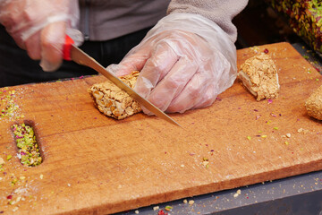 cutting Turkish traditional sweet Turkish delight on a chopping board 