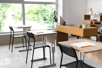Interior of stylish empty classroom prepared for exam