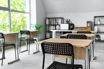 Desks and chairs in empty classroom at school