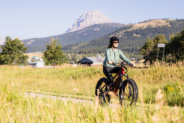 Fototapeta premium Woman Cycling in Scenic Crowsnest Pass Alberta Landscape