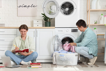 Male students studying in dorm laundry room