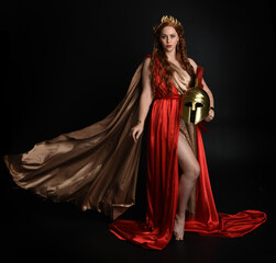 Full length portrait of beautiful female model wearing grecian red silk gold roman robes,...