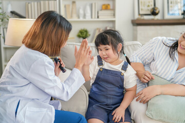 Fototapeta premium happy adorable asian child girl giving high five with young female doctor in examining room at dental clinic,a little kid being encouraged by dentist