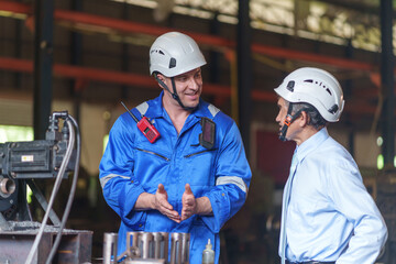 an experienced manager giving advice work instruction to employee,a caucasian technician in the factory