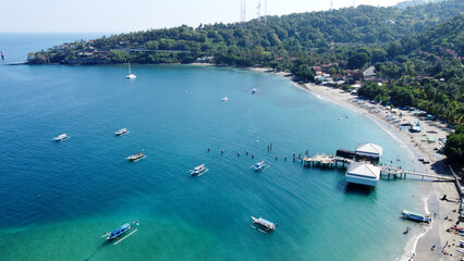 Aerial view of Senggigi beach in sunny day, ships docked on the coast of Senggigi, floating ships on the beach, Lombok Island, Indonesia