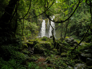 Spun Waterfall in Sapun Village, Boklua, Nan province, is a hidden paradise where crystal-clear waters cascade over moss-covered rocks, surrounded by dense, vibrant jungle, offering a tranquil retreat
