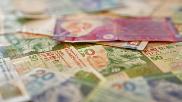 Closeup of colorful hong kong dollar banknotes spread out, showcasing various denominations and intricate designs in a vibrant, detailed pattern
