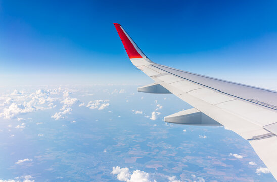 Fototapeta View from the airplane window at a beautiful cloudy sky and the airplane wing