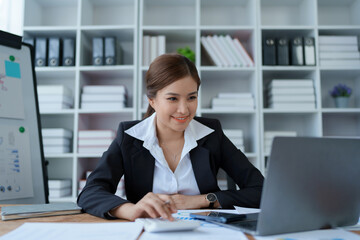 woman meticulously plans a finance audit, using a computer and calculator to review budget...