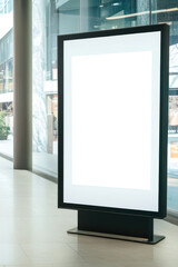 Fototapeta premium A blank advertising poster mockup is positioned in a contemporary shopping center, showcasing a minimalist design for promotional purposes