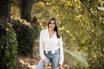 Autumn fall. Portrait young woman with autumn leafs on foliage. Beautiful girl outdoor in autumn. Sensual woman with yellow leaves in autumn. Pretty woman with leaf near face on autumnal background.