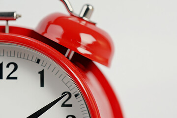 A red alarm clock with a white face showing the time as 10:30. The clock is set to go off at 10:35