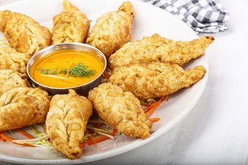 Fried stuffed momo dumplings with sauce