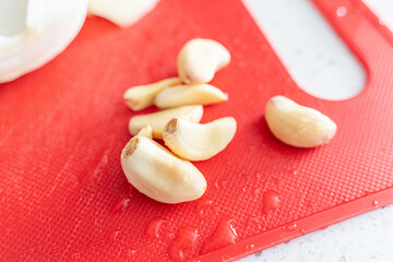 garlic cloves on a red chopping board in the Kitchen