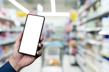 Personal perspective of a woman's hand holding up a smartphone while grocery shopping in supermarket