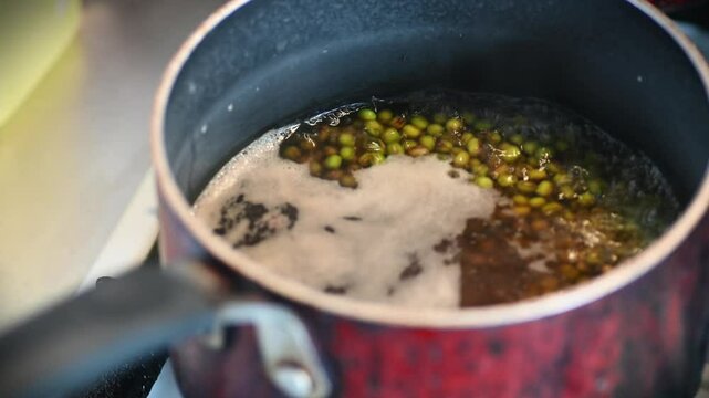 Boiling monggo or mung beans in a pot