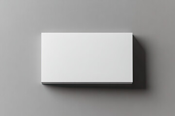 A mockup of a white, blank rectangular box on a grey background, top view, with a soft shadow. Created with Ai