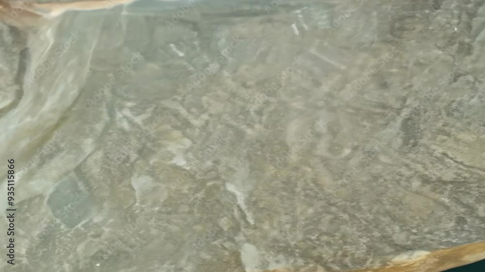 Poster Exploring the serene patterns of water cascading over smooth stones in a tranquil natural setting