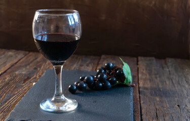 Red Wine Glass and Grape Bunch on a Wooden Table