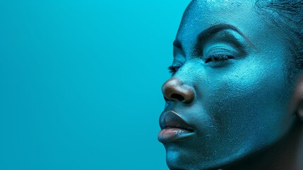  A tight shot of a woman's face, adorned with blue powder around her eyes that are gently shut towards the side