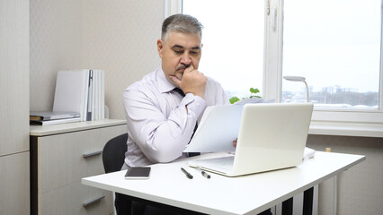 Businessman at Desk in Office Working with Documents