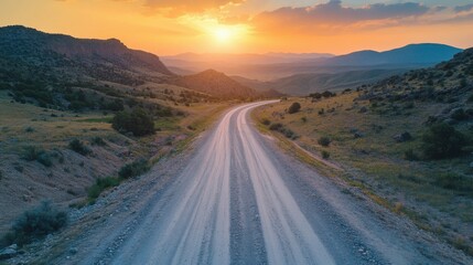 Fototapeta premium photo of a narrow winding asphalt wet road in a mountainous area at sunset. Top view.