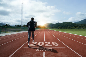 New year resolution 2025 concept. Word start 2025 written on athletics track and athlete woman...