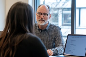 A one-on-one coaching session occurs in a bright conference room, with the mentor guiding the client through a presentation