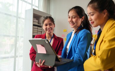 A group of businesswomen meet to discuss, brainstorm, and record in notebooks. Brainstorming with colleagues in the office Project analysis report Check investment results and company profits.