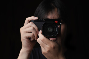 photographer take pictures Snapshot with camera. man hand holding with camera looking through lens.Concept for photographing articles Professionally.
