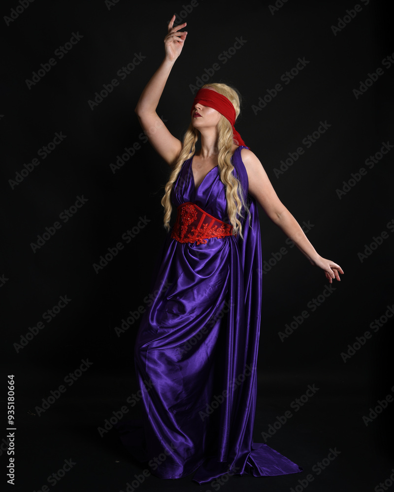 Canvas Prints Close up portrait of beautiful blonde female model wearing silk grecian toga dress and red blindfold, historical fantasy goddess,  isolated on dark studio background.