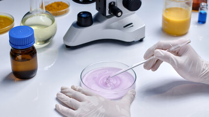 Cosmetic experiment photo for advertising was taken from high angle, a glass petri dish contains...