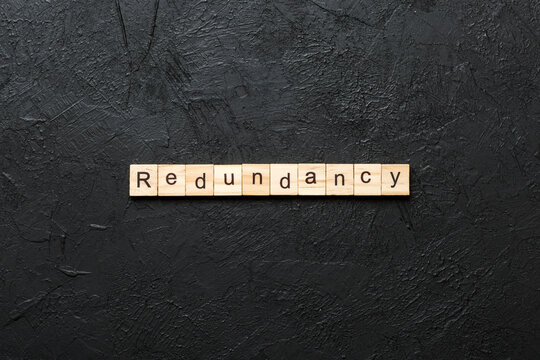 redundance word written on wood block. redundance text on table, concept