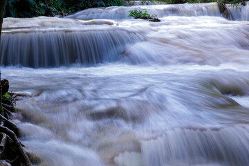 Huay Mae Khamin Waterfall, clear and cool water amidst the lush green forest.