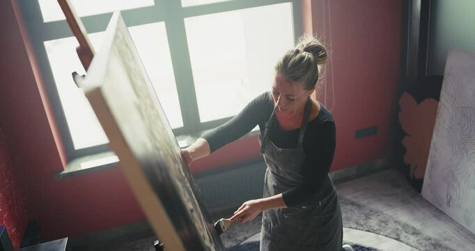 Woman in Apron Painting Leopard on Easel