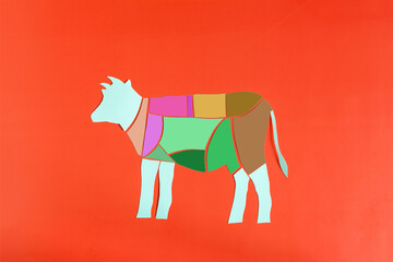 Color scheme of beef carcass made of cardboard on a bright red background close-up