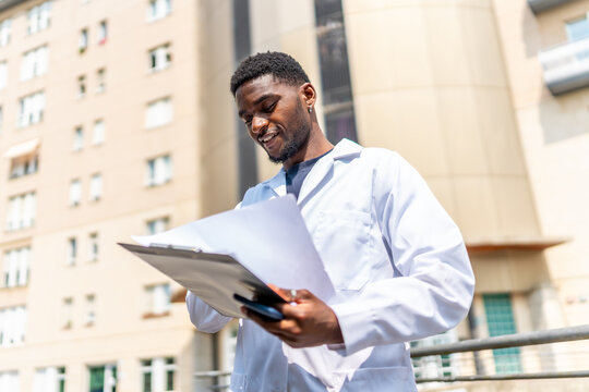 African doctor with paperwork outside the hospital