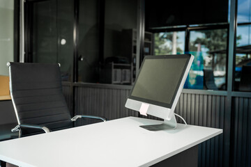Fototapeta premium A modern office desk with a laptop, monitor, and plant. sleek, minimal design features open space, technology and productivity. room is empty, offering a clean and organized workspace.