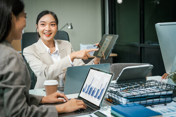 Asian colleagues meet at a desk, discussing business financial terms, investment strategies, managing funds. Their focus is on planning, analysis, and operations to ensure stability and success.