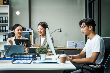 Asian colleagues meet at a desk, discussing business financial terms, investment strategies, managing funds. Their focus is on planning, analysis, and operations to ensure stability and success.