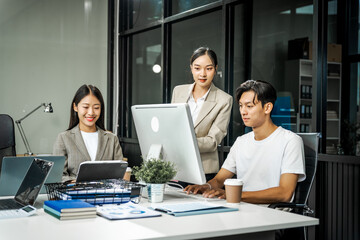 Asian colleagues meet at a desk, discussing business financial terms, investment strategies,...