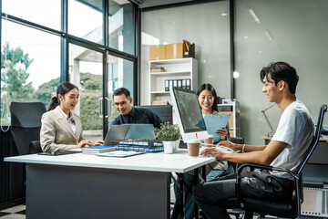 Asian colleagues meet at a desk, discussing business financial terms, investment strategies,...