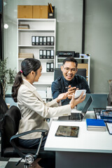 Asian colleagues meet at a desk, discussing business financial terms, investment strategies,...