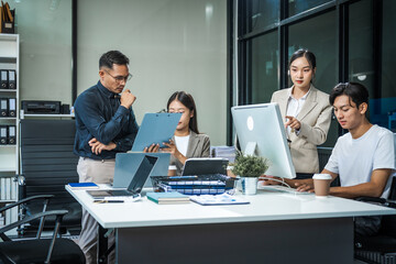 Asian colleagues meet at a desk, discussing business financial terms, investment strategies,...
