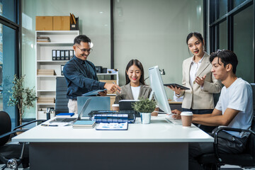 Asian colleagues meet at a desk, discussing business financial terms, investment strategies, managing funds. Their focus is on planning, analysis, and operations to ensure stability and success.