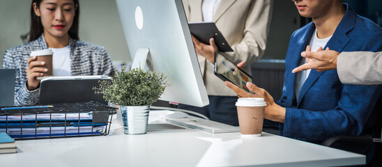 Asian colleagues meet at a desk, discussing business financial terms, investment strategies,...