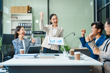 In a boardroom, an Asian team meets at a desk, presenting financial terms and strategies. Executives and employees collaborate, sharing ideas and work guidelines for success during an annual meeting.